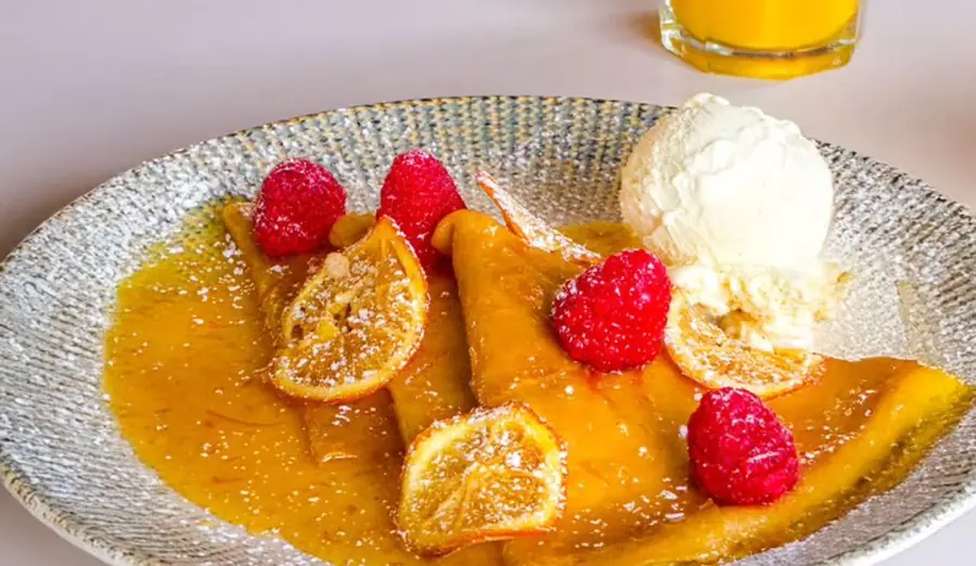 Crêpes à l'orange façon Suzette, framboises, oranges confites et boule de glace vanille